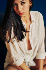 Fototapeta premium boudoir portrait of a young beautiful in a shirt on the bed