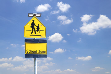 School zone sign with sky background. Sign showing school area.