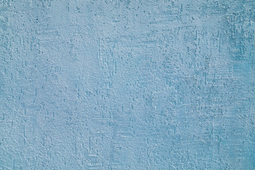 Background of a shrapnel plaster cement wall painted blue.