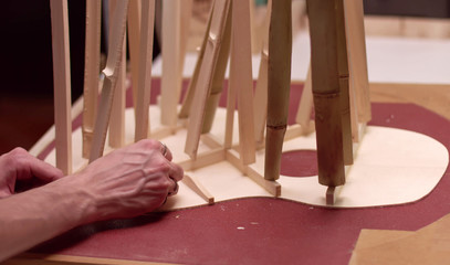 Close up of luthier building wooden guitar soundboard