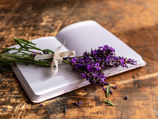 Obraz na płótnie Canvas Frischer Lavendel auf einem offenen Tagebuch, rustikaler Stil