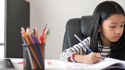 Asian little girl doing homework select focus shallow depth of field