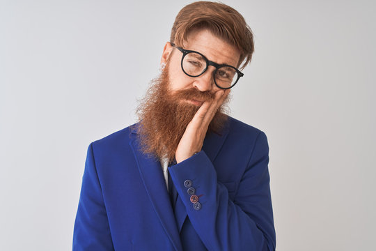 Young redhead irish businessman wearing suit and glasses over isolated white background thinking looking tired and bored with depression problems with crossed arms.