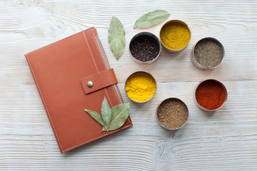 spice and notepad on a white wooden background