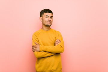 Young hispanic man smiling confident with crossed arms.