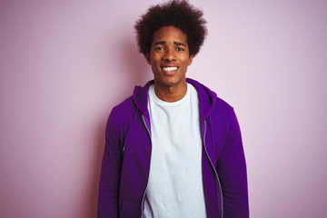 Fototapeta premium Young african american man wearing purple sweatshirt standing over isolated pink background with a happy and cool smile on face. Lucky person.