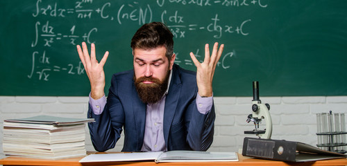 Teaching dumb students. Teacher mature man. Fed up. Difficult work. Emotional burnout. Teacher give up. Hate his job. Man desperate teacher in classroom. No hope for better. Tired and exhausted