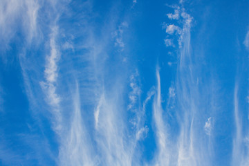 Dramatic blue sky with streaks of vertical clouds.