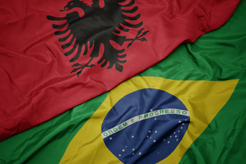 waving colorful flag of brazil and national flag of albania.