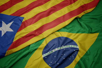 waving colorful flag of brazil and national flag of catalonia.