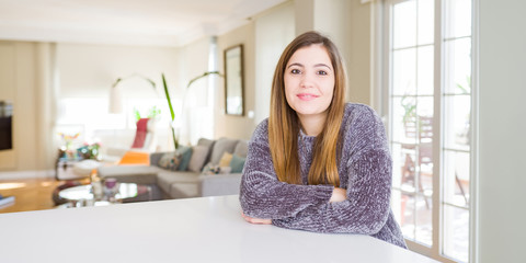Beautiful young woman at home happy face smiling with crossed arms looking at the camera. Positive person.