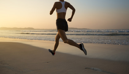 Fototapeta na wymiar Fitness woman runner running on sunrise beach