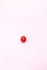 Flat lay. Food concept. Red ripe tomato on a pink background