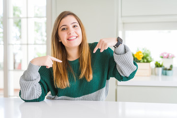 Young beautiful plus size woman wearing casual striped sweater looking confident with smile on...
