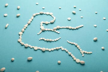 Silhouette of muscular arm made of pills of sport meal and supplements. Amino acid, whey protein, creatine, beta-alanine and taurine capsules.