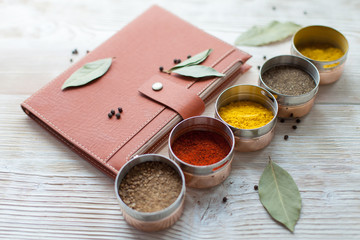 spice and notepad on a white wooden background