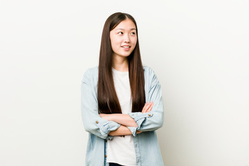 Young asian woman smiling confident with crossed arms.