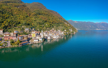 Fototapeta na wymiar Aerial view landscape on beatiful Lake Como in Lombardy, Italy. Scenic small town with traditional houses and clear blue water. Summer tourist vacation on rich resort with nice harbour