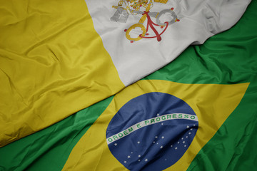 waving colorful flag of brazil and national flag of vatican city.