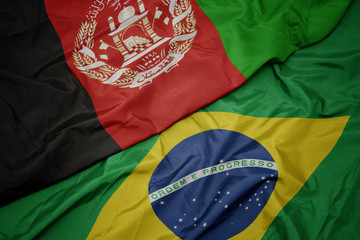 waving colorful flag of brazil and national flag of afghanistan.