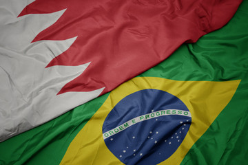 waving colorful flag of brazil and national flag of bahrain.