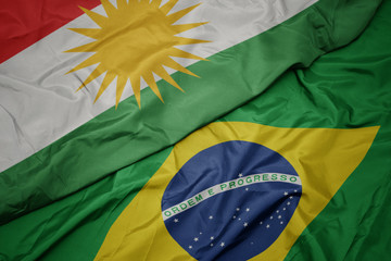 waving colorful flag of brazil and national flag of kurdistan.
