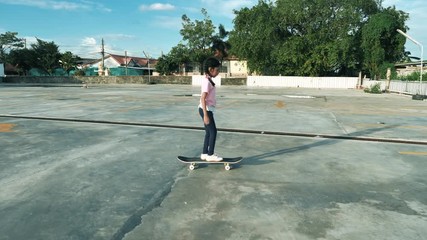 Slow motion little Asian girl playing skateboard with happiness