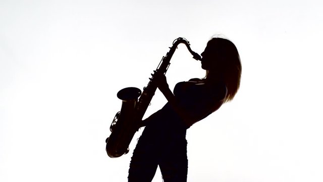 Silhouette of female who playing saxophone