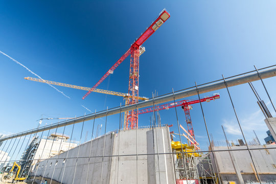 Large construction site with construction fence and cranes