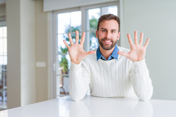 Handsome man wearing casual sweater showing and pointing up with fingers number ten while smiling confident and happy.