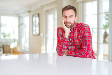 Handsome man wearing colorful shirt thinking looking tired and bored with depression problems with crossed arms.