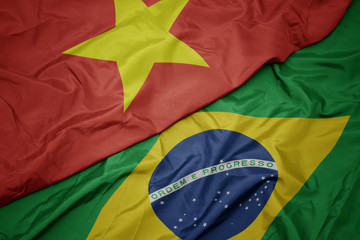 waving colorful flag of brazil and national flag of vietnam.