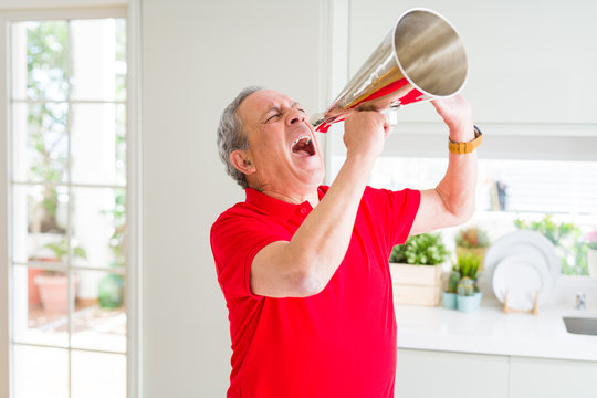 Senior man shouthing excited through vintage metal megaphone