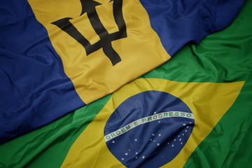 waving colorful flag of brazil and national flag of barbados.