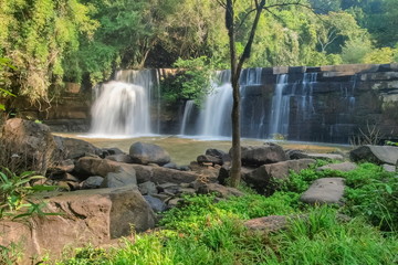Obraz premium view of waterfall flowing around with arch rocks and green forest background, Sridit Waterfall, Khao Kho, Phetchabun, thailand.