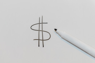 pen drawing dollar symbol on blackboard