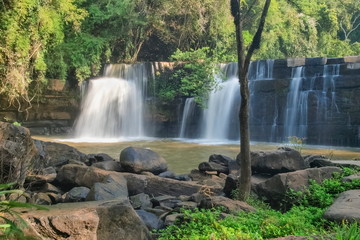 Fototapeta premium view of waterfall flowing around with arch rocks and green forest background, Sridit Waterfall, Khao Kho, Phetchabun, thailand.