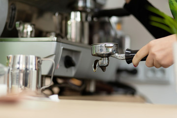 Barista girl is preparing aromatic coffee with a coffee machine. Barista work in a coffee shop