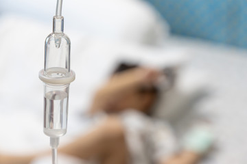 intravenous drip with blur kid patient background. iv fluid treatment.
