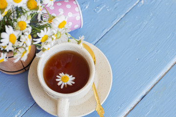 cup of herbal chamomile tea with fresh daisy flowers on wooden background. doctor treatment and prevention of immune concept, medicine - folk, alternative, complementary, traditional medicine
