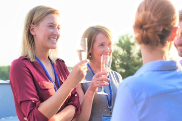 Businessman colleagues holding wineglasses during success party at terrace