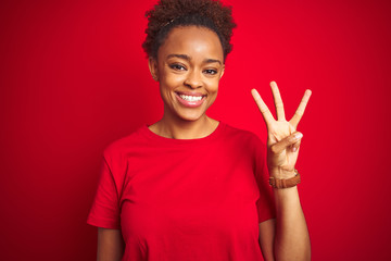 Young beautiful african american woman with afro hair over isolated red background showing and...