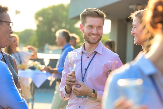 Smiling Business Colleagues Talking During Success Party On Rooftop