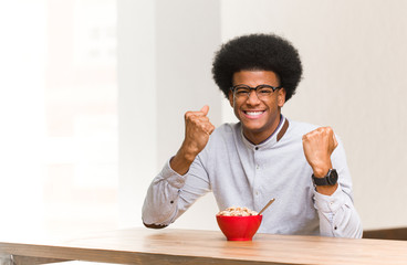 Fototapeta na wymiar Young black man having a breakfast surprised and shocked