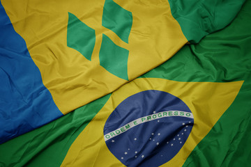 Fototapeta na wymiar waving colorful flag of brazil and national flag of saint vincent and the grenadines.