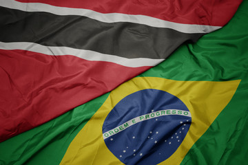 waving colorful flag of brazil and national flag of trinidad and tobago.