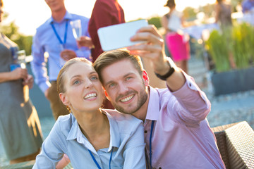 Obraz premium Businessman taking selfie with colleague during rooftop party