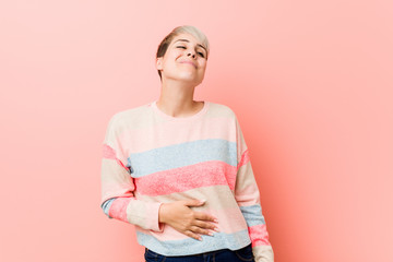 Young natural curvy woman touches tummy, smiles gently, eating and satisfaction concept.