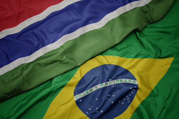 waving colorful flag of brazil and national flag of gambia.