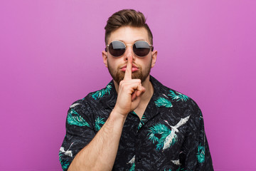 Young man wearing a vacation look keeping a secret or asking for silence.